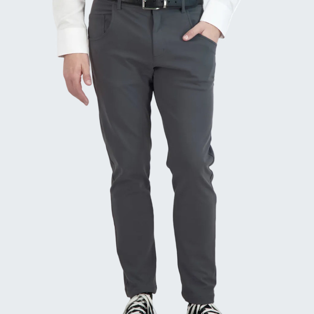 Person wearing gray pants and black sneakers on a white background