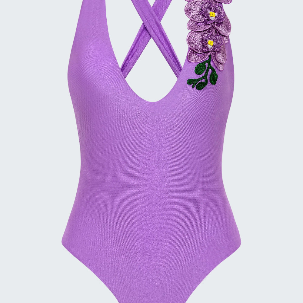 Purple swimsuit with floral design on a white background