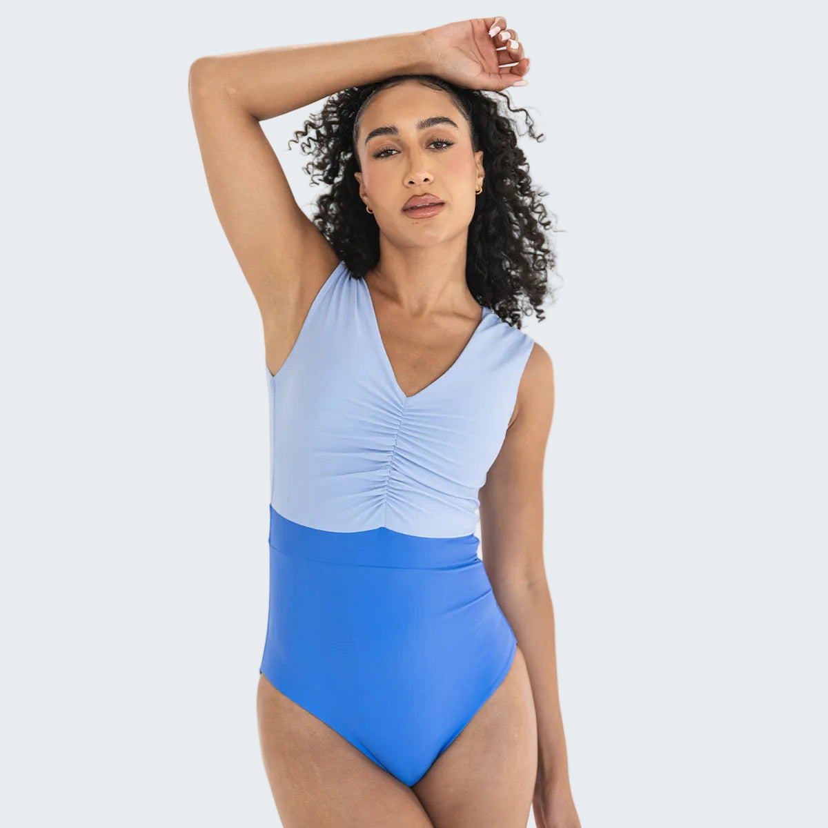Woman wearing a blue and light blue one-piece swimsuit on a white background