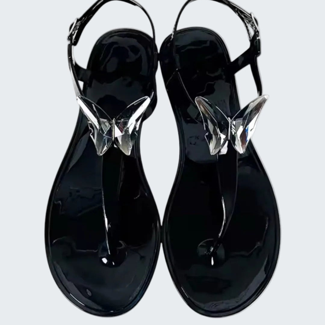 Black jelly sandals with clear straps on a white background