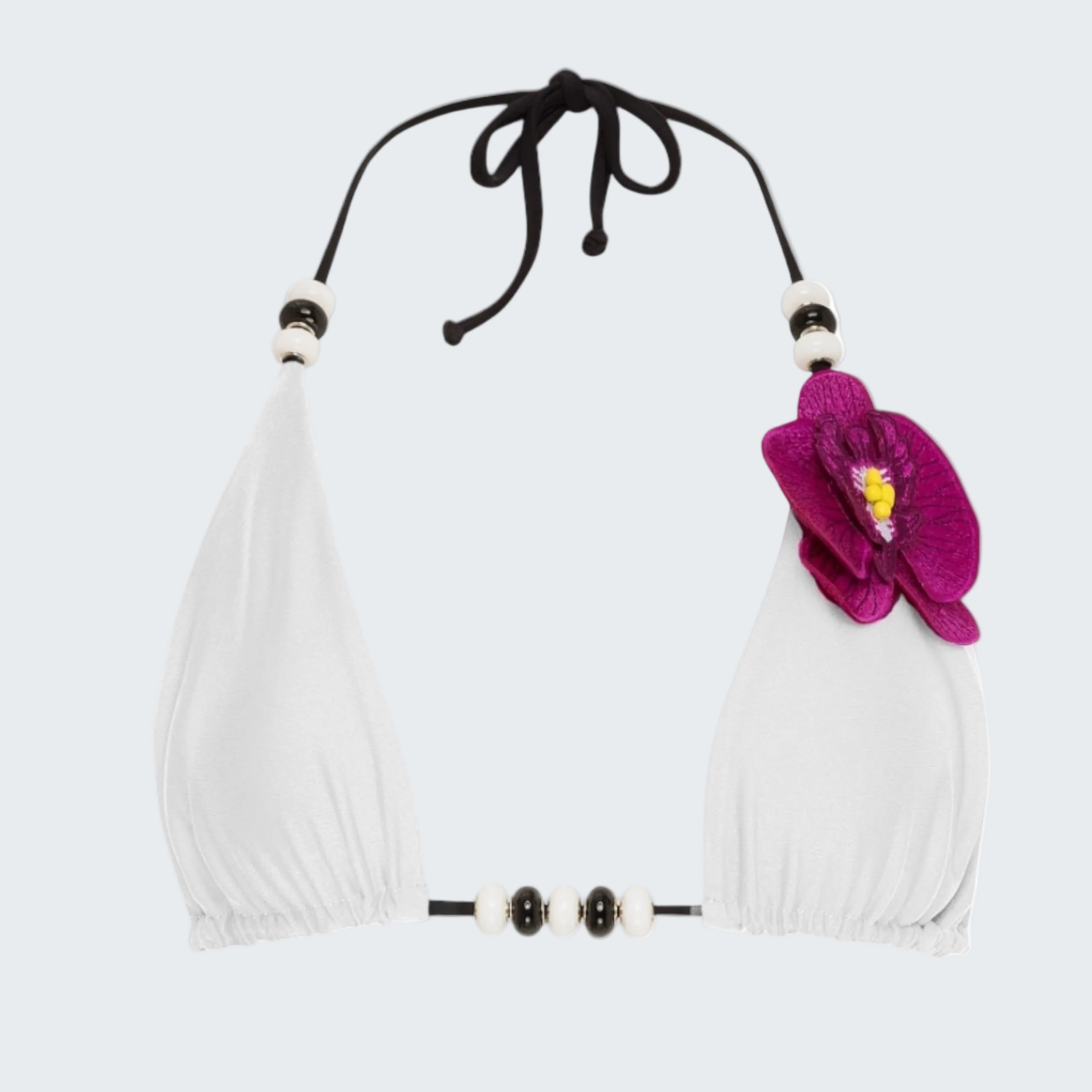 White bikini top with black straps and a pink flower on a white background