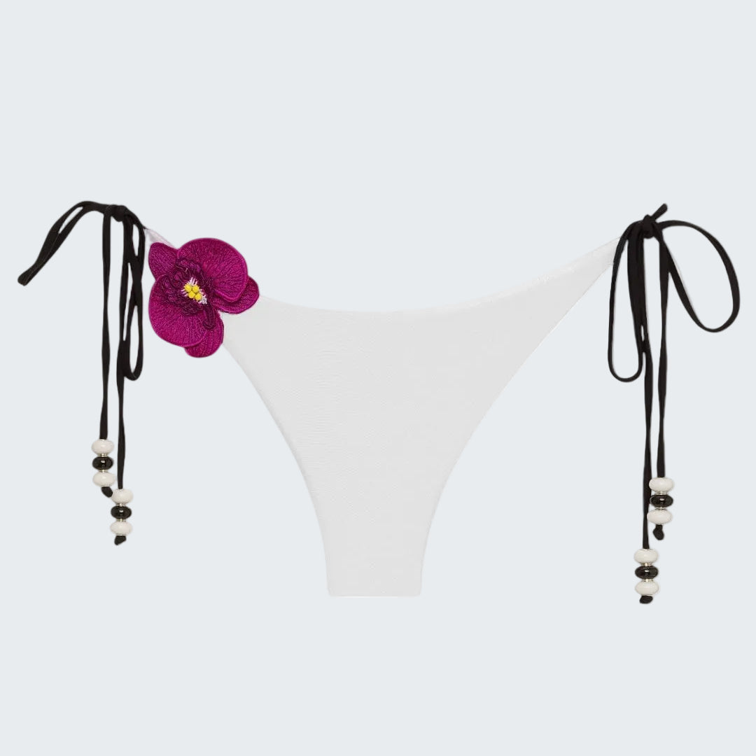 White bikini bottom with floral design and black straps on a white background