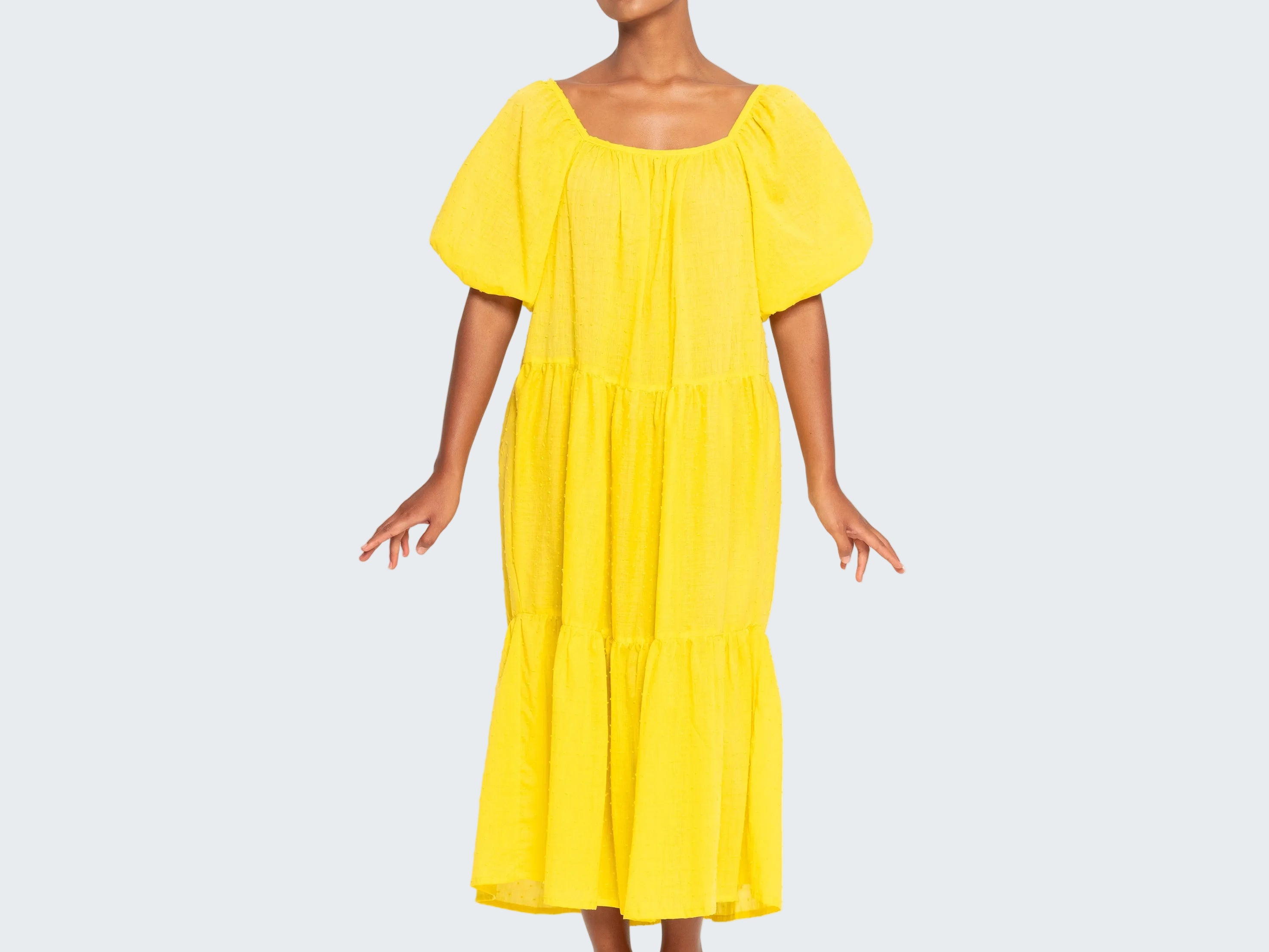 Woman wearing a yellow dress on a white background