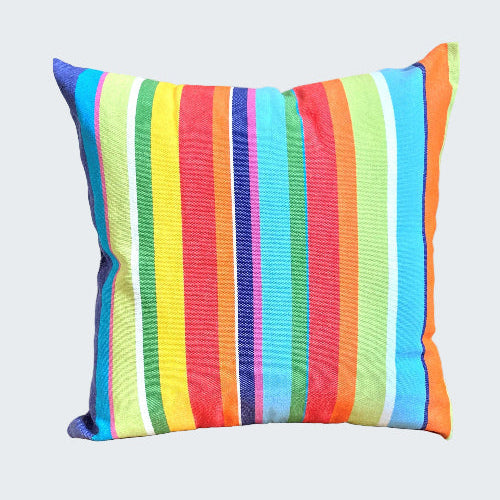 Colorful striped pillow on a wooden stool against a neutral wall