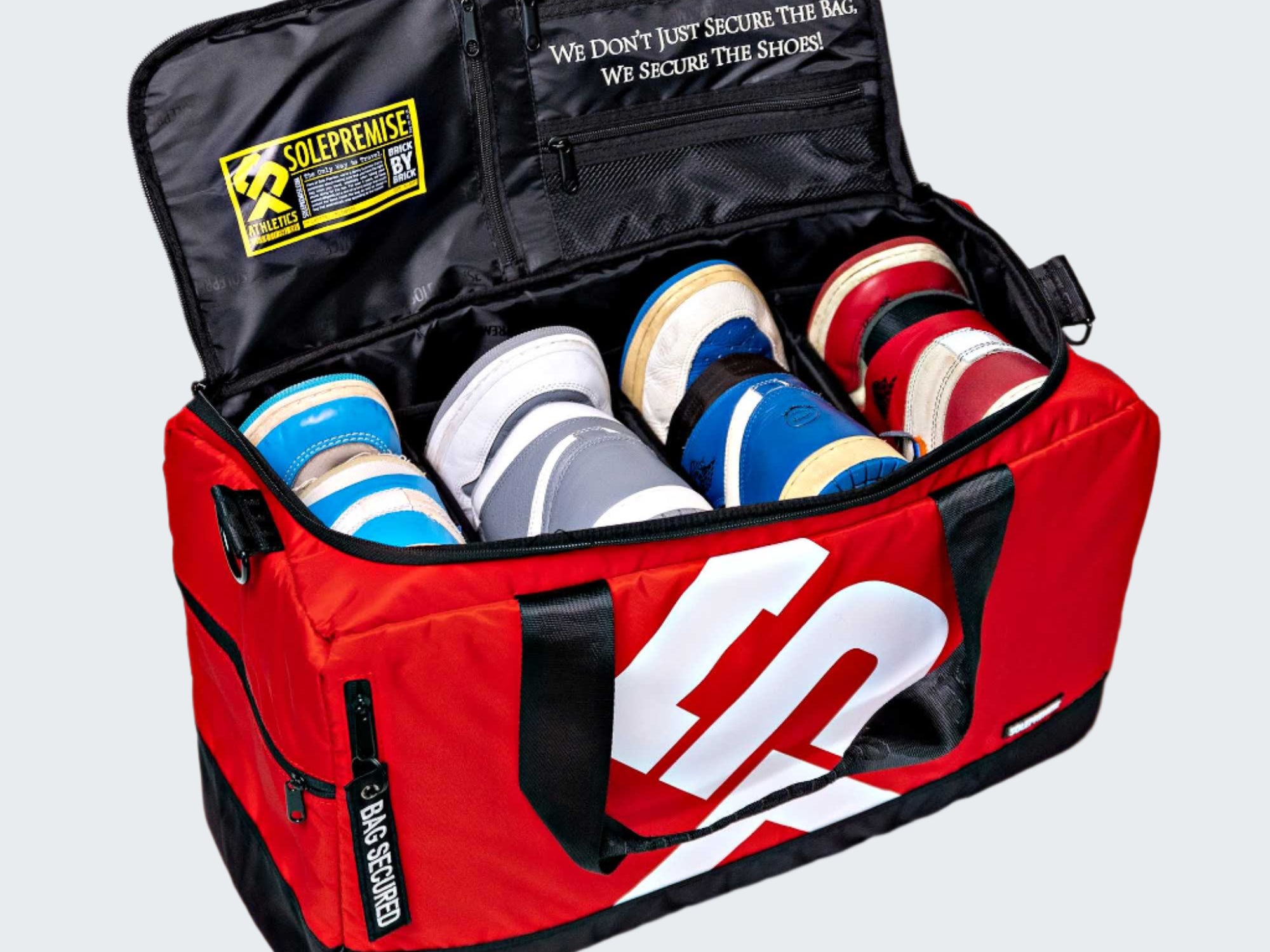 Red sports bag with white logo containing various shoes on a white background