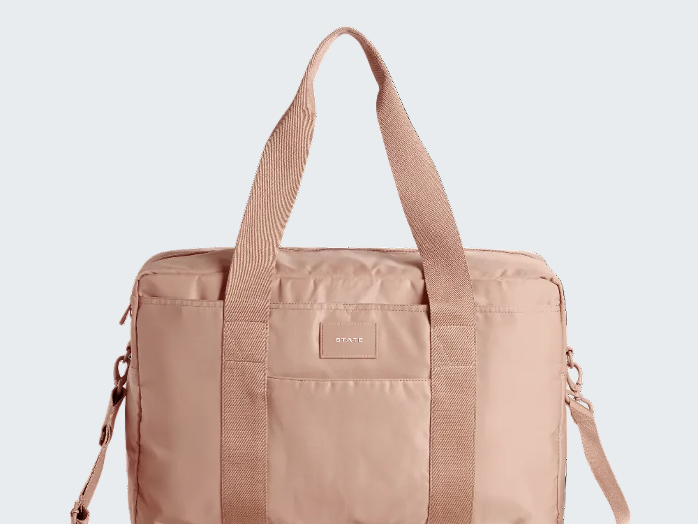 Beige duffel bag with shoulder straps on a white background