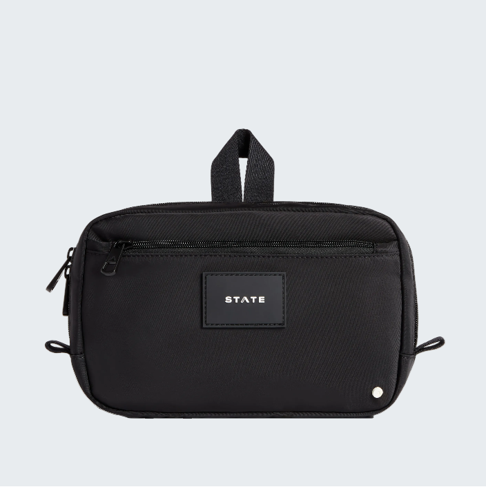 Black toiletry bag with 'STATE' label on a white background
