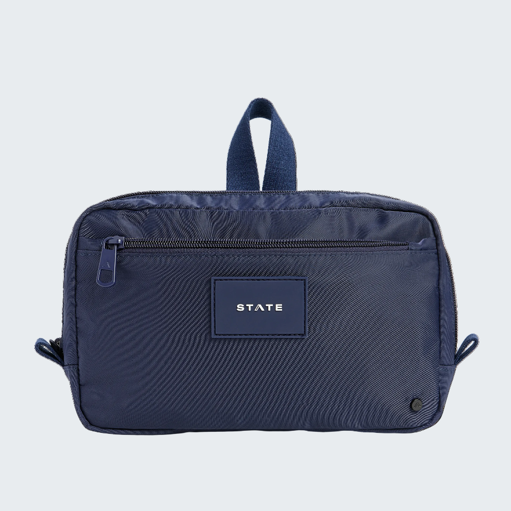 Navy blue toiletry bag with 'STATE' label on a white background