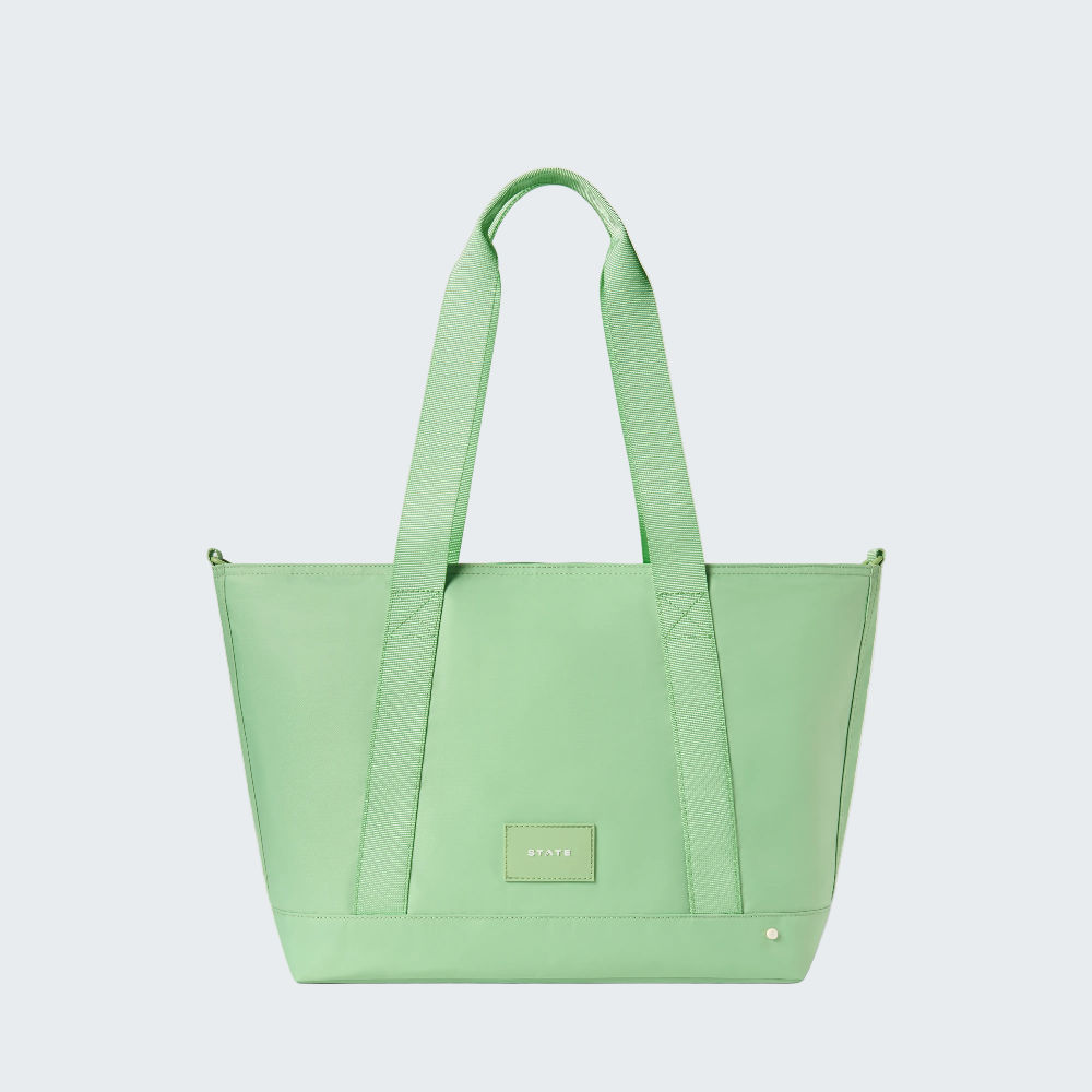 Green tote bag with a visible brand logo on a white background