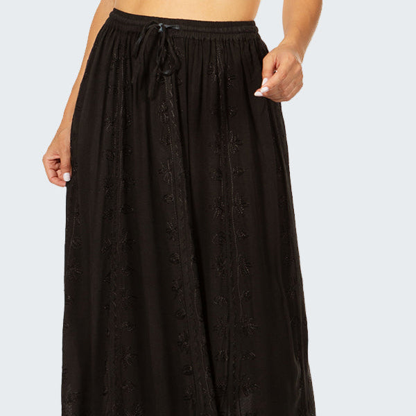Black long skirt worn by a person on a white background
