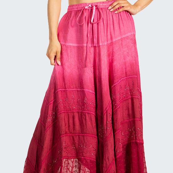 Woman wearing a white crop top and pink long skirt on a white background