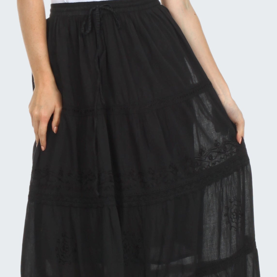 Black lace-trimmed skirt worn by a person on a white background