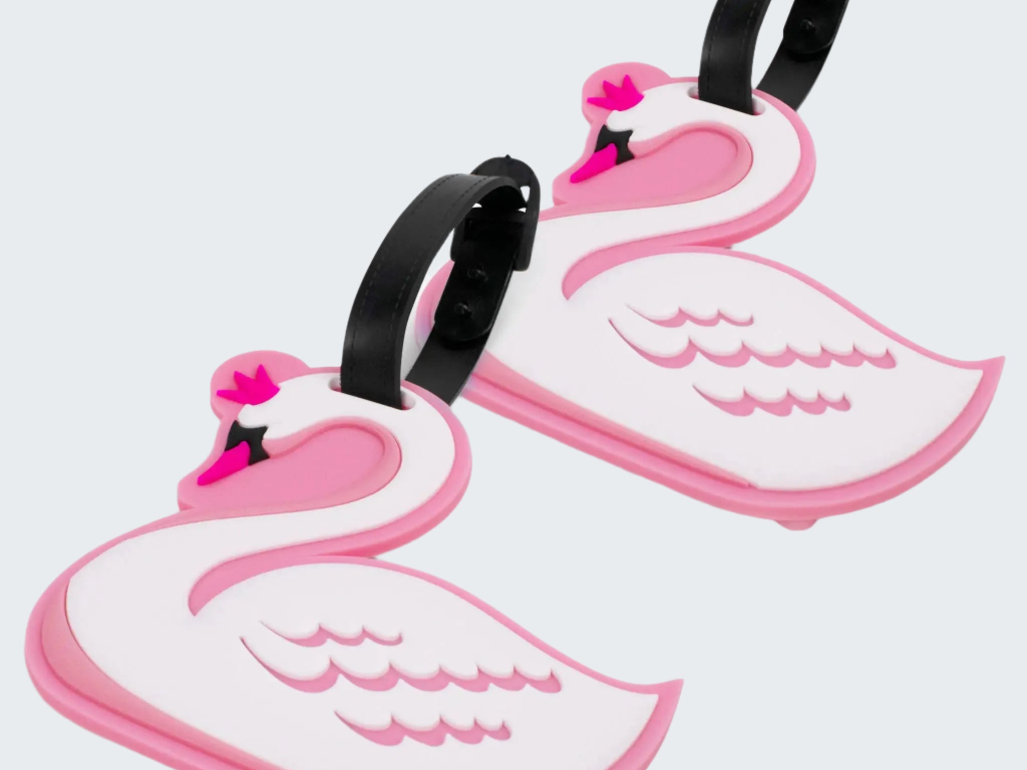 Two pink and white swan-shaped luggage tags on a white background