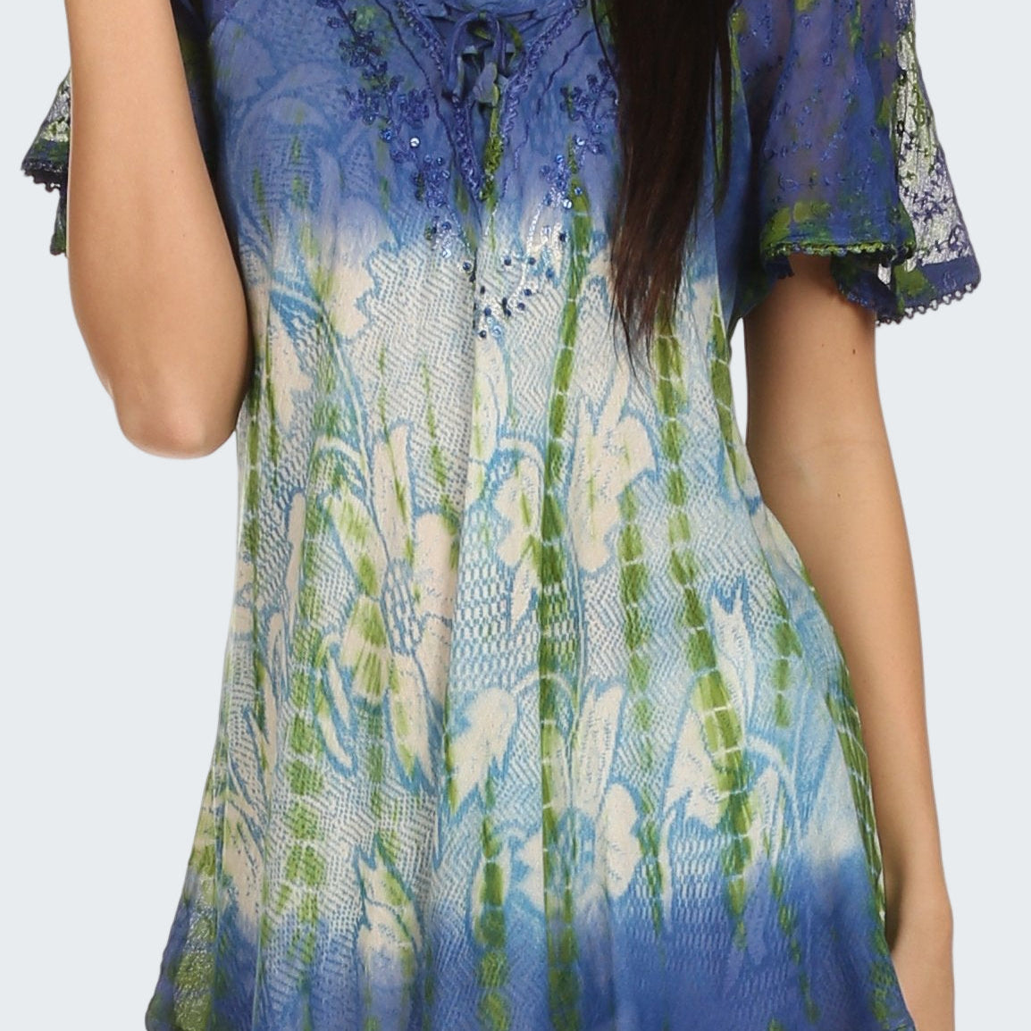 Woman wearing a colorful patterned top with short sleeves on a white background
