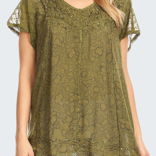 Green lace top with embellishments worn by a model on a white background
