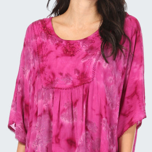 Pink tie-dye top worn by a person on a white background