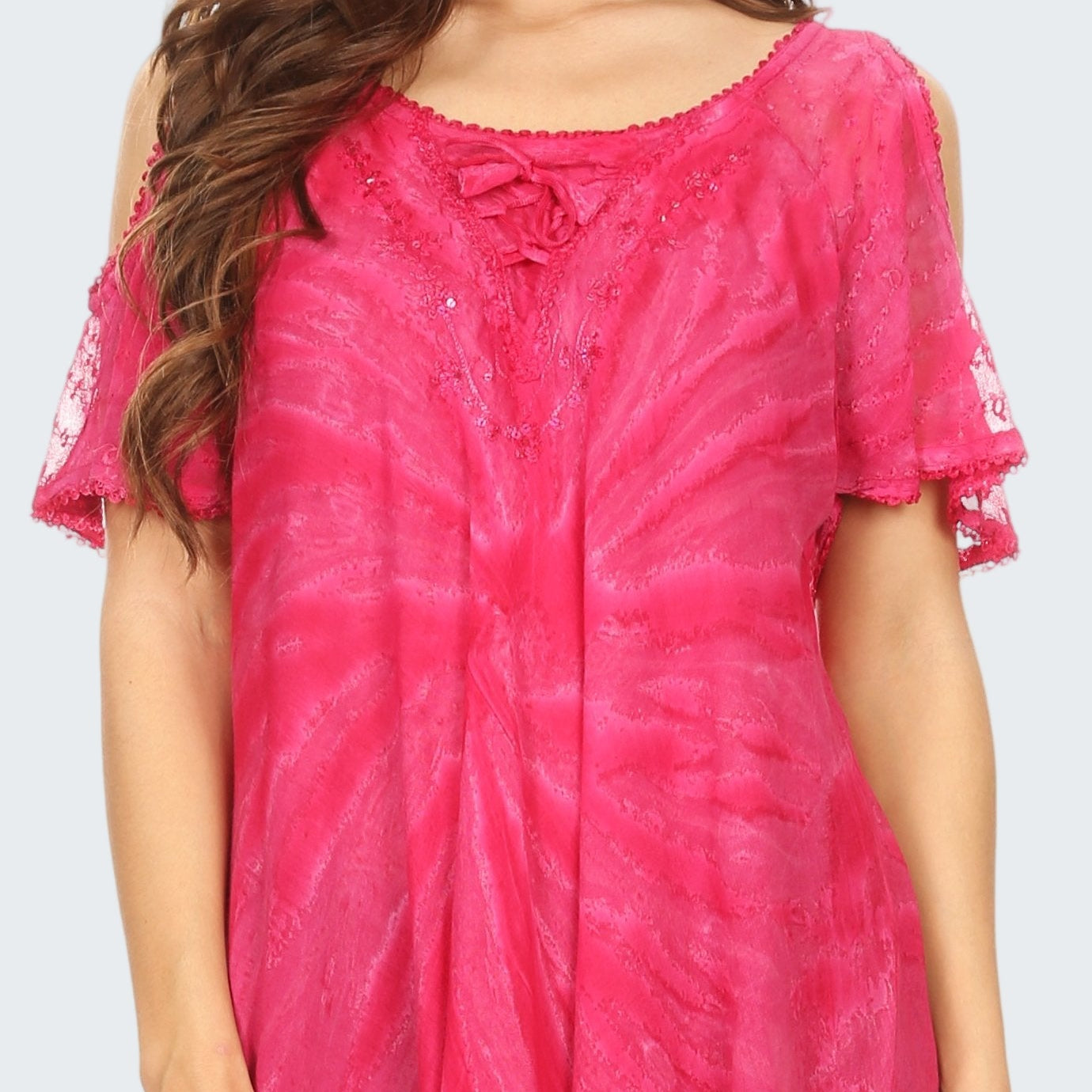 Woman wearing a pink tie-dye top with a plain background