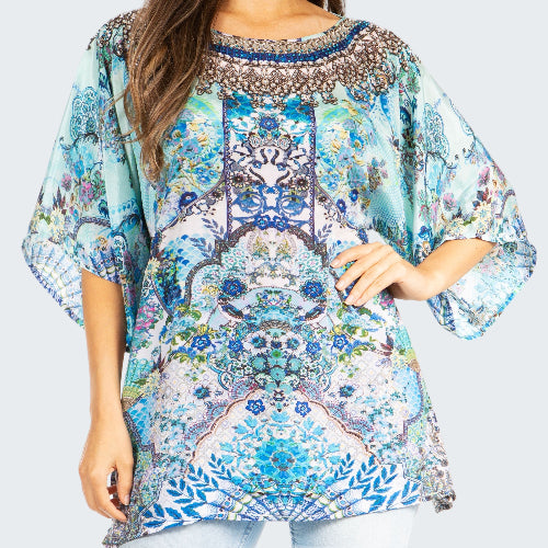 Woman wearing a colorful patterned blouse on a white background