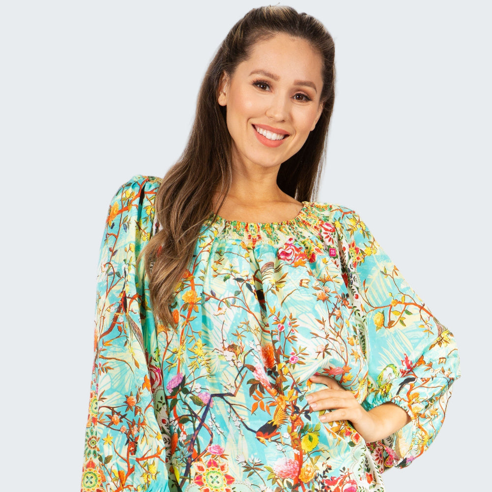 Woman wearing a colorful floral blouse with a white background