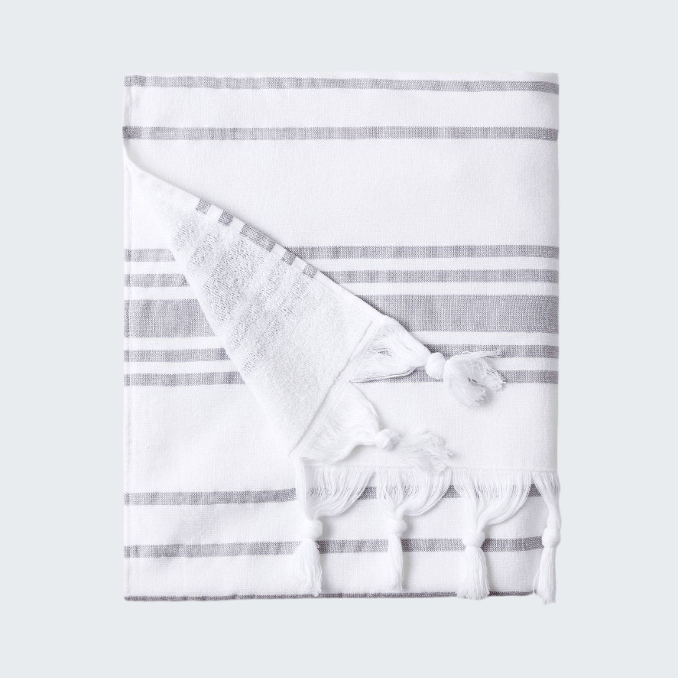 White towel with gray stripes and tassels on a white background
