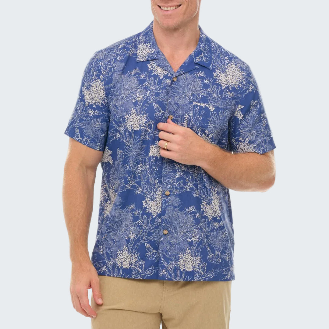 Man wearing a blue floral patterned shirt on a white background