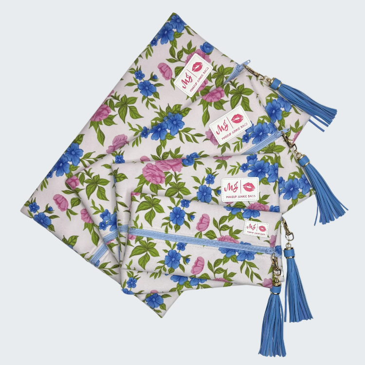 Set of floral pouches with blue tassels and a visible brand label on a white background