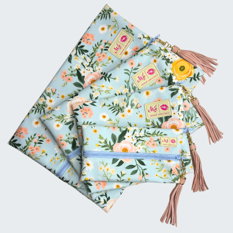 Set of floral-patterned pouches with tassels on a white background