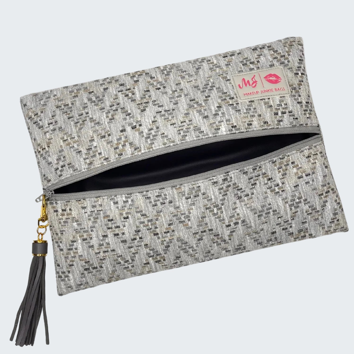 Gray textured clutch bag with a tassel on a white background