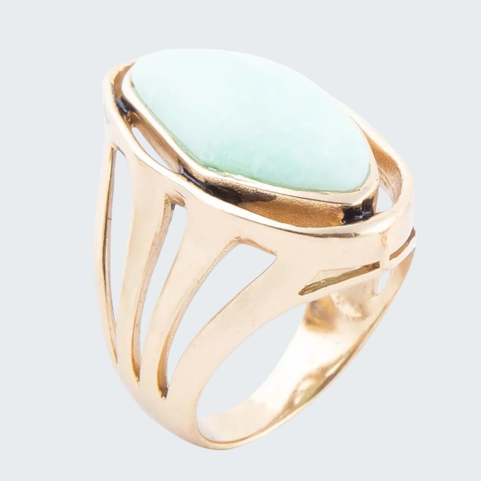 Gold ring with a light green stone on a white background