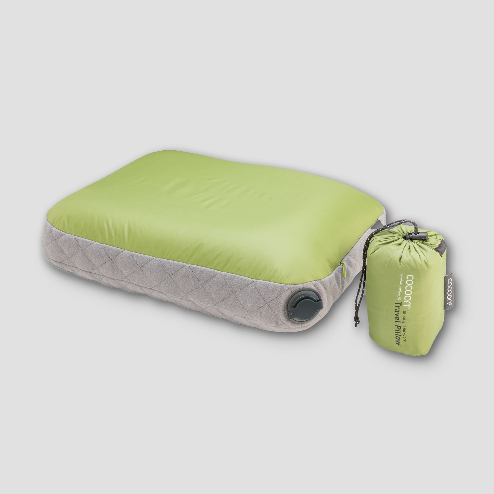 Green and gray inflatable travel pillow with a matching storage bag on a light gray background