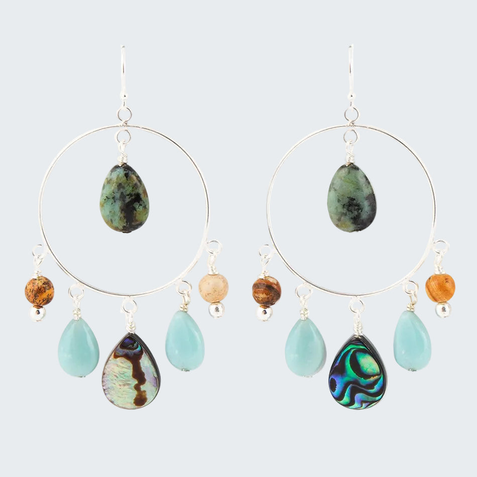 Pair of hoop earrings with teardrop-shaped gemstones on a white background