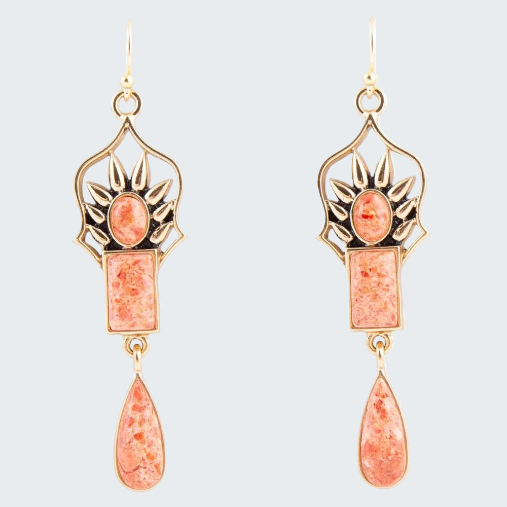 Pair of earrings with pink stone and gold accents on a white background