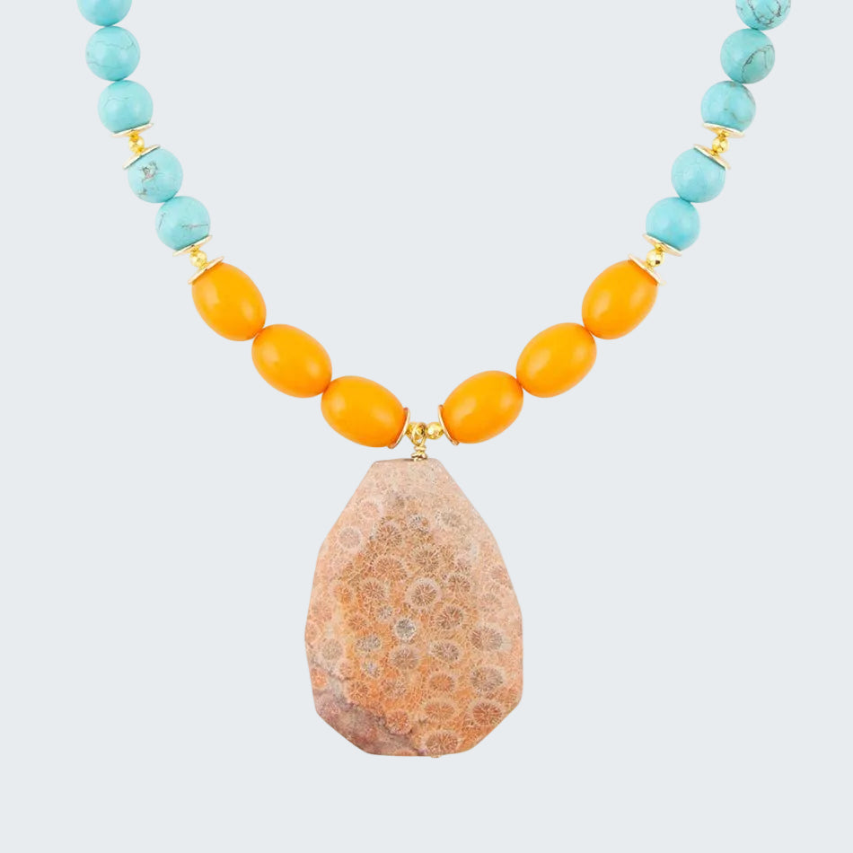 Necklace with turquoise and orange beads and a large stone pendant on a white background