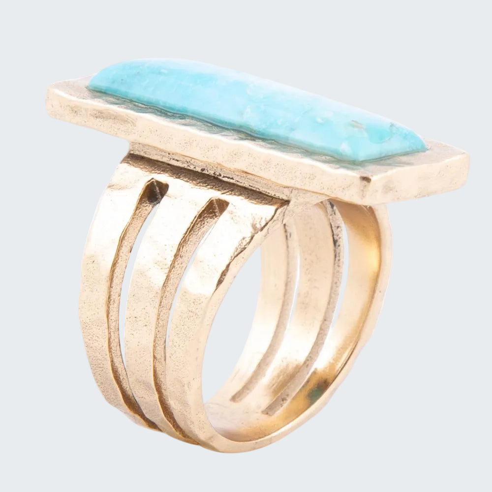 Gold ring with a rectangular turquoise stone on a white background