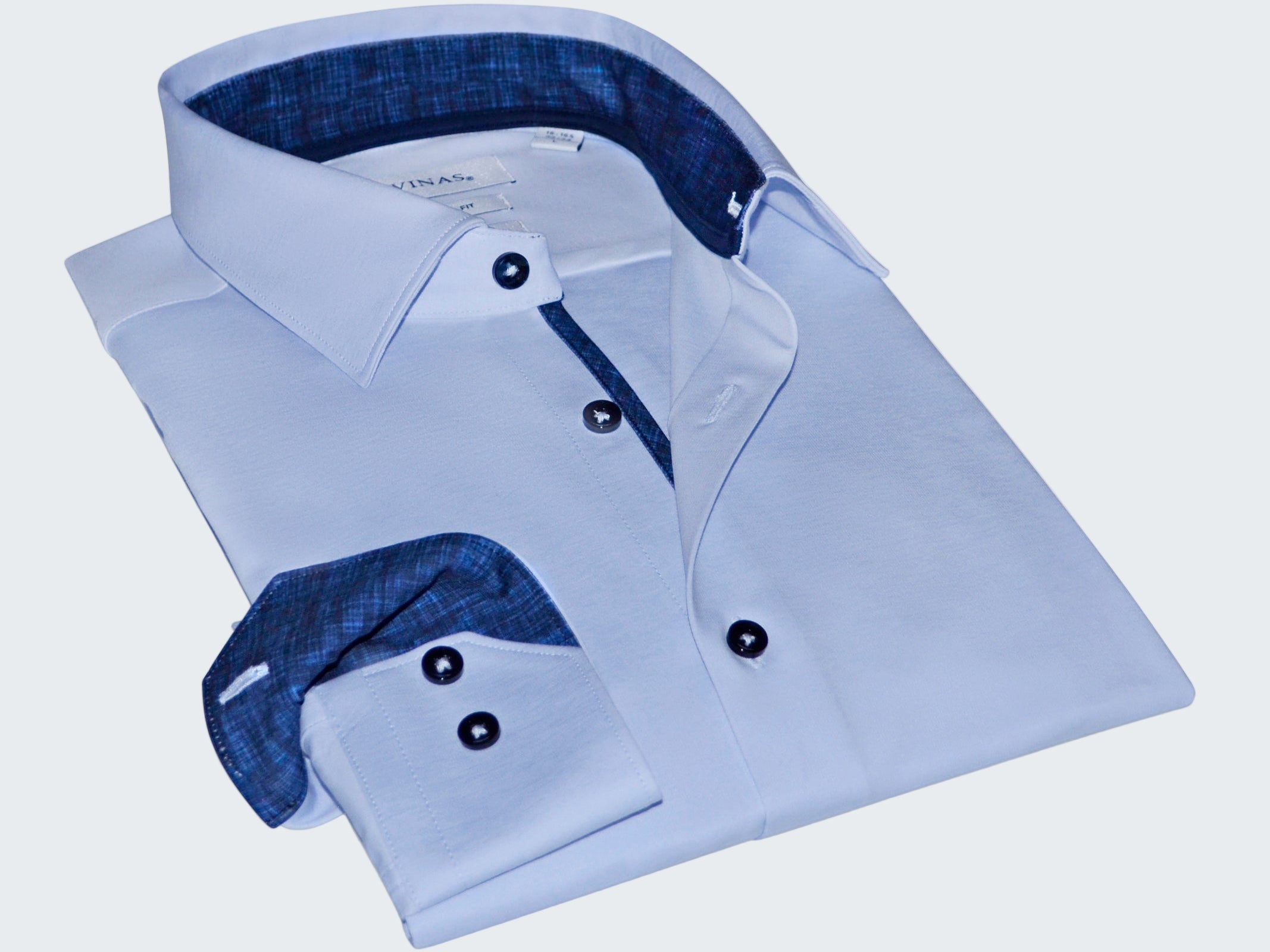 Folded light blue dress shirt with dark blue interior on a white background