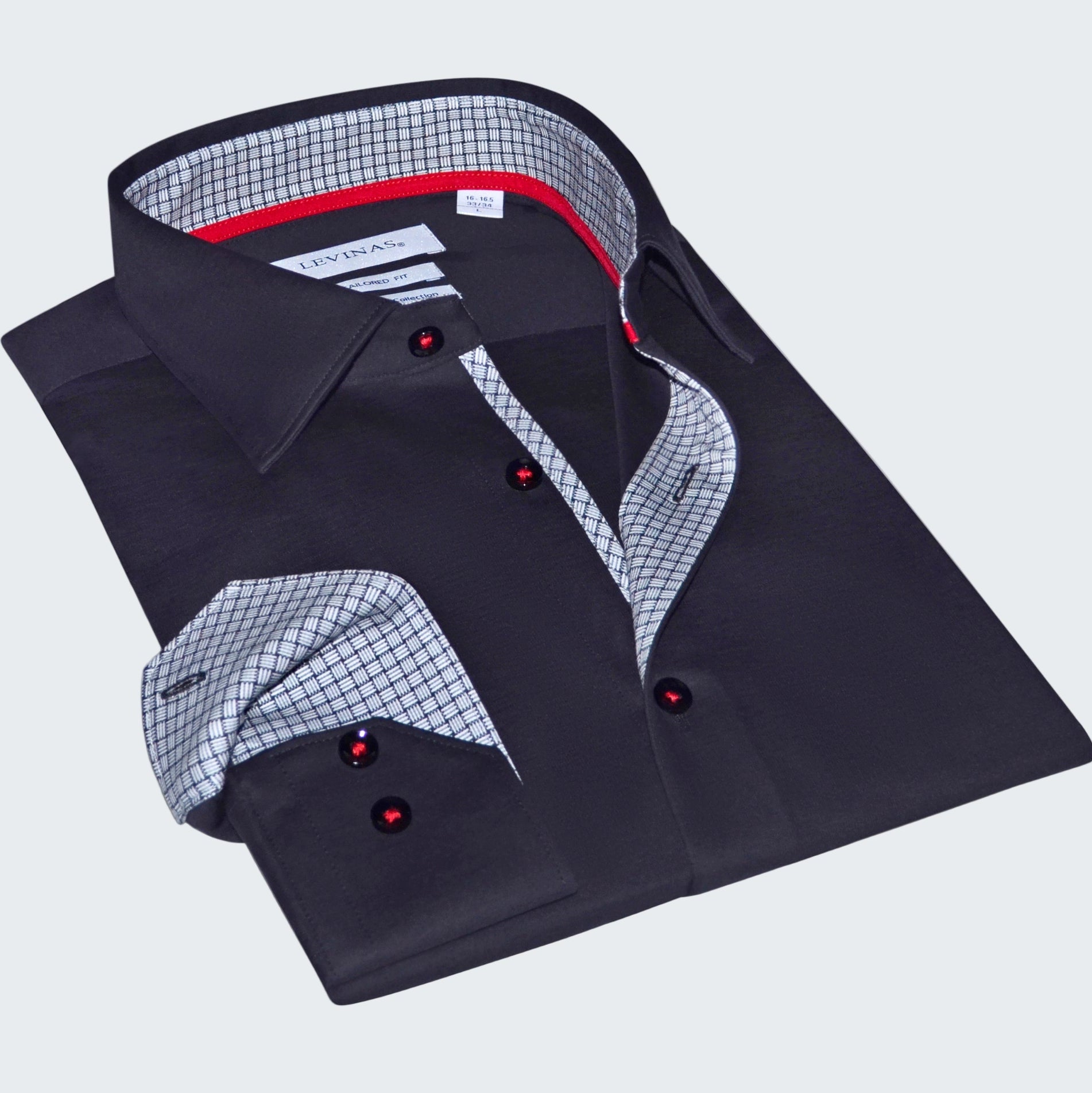 Folded black dress shirt with red buttons on a white background