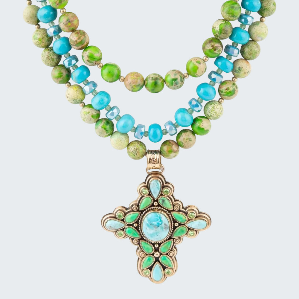 Necklace with green and blue beads and a decorative pendant on a white background