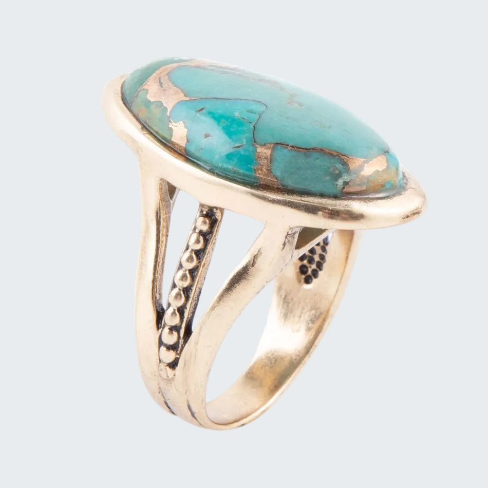 Gold ring with a large turquoise stone on a white background