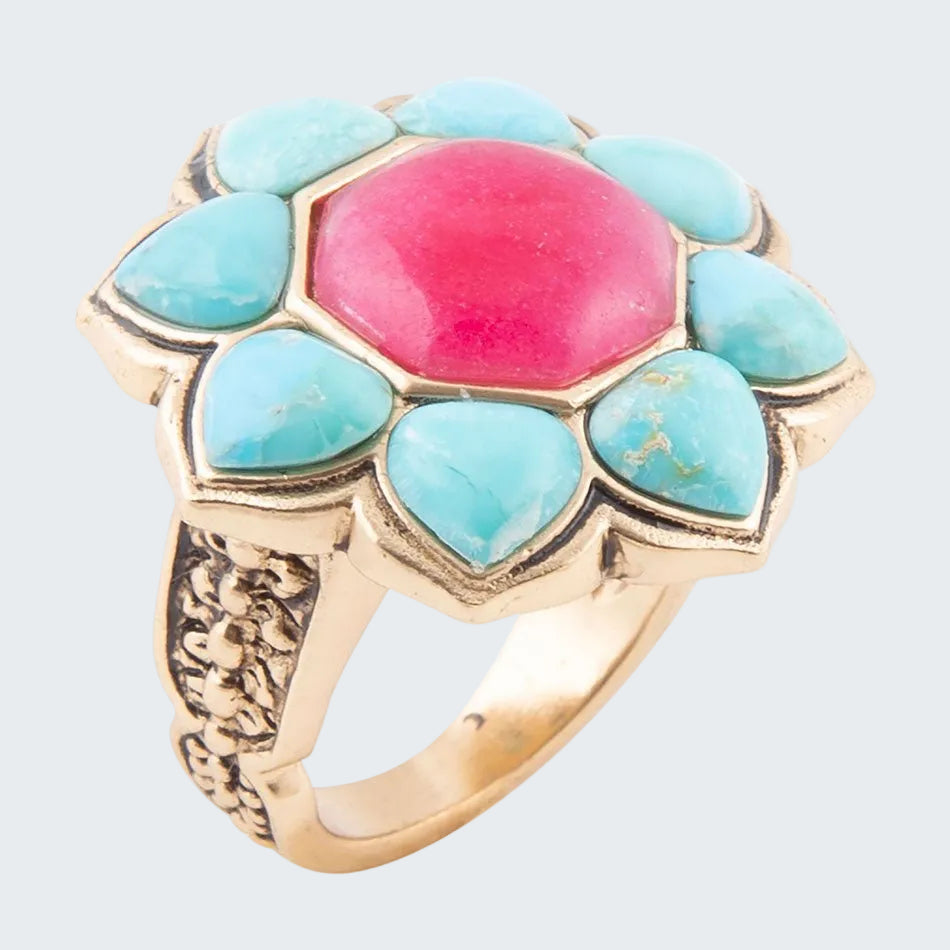 Ring with turquoise stones and a pink center on a white background