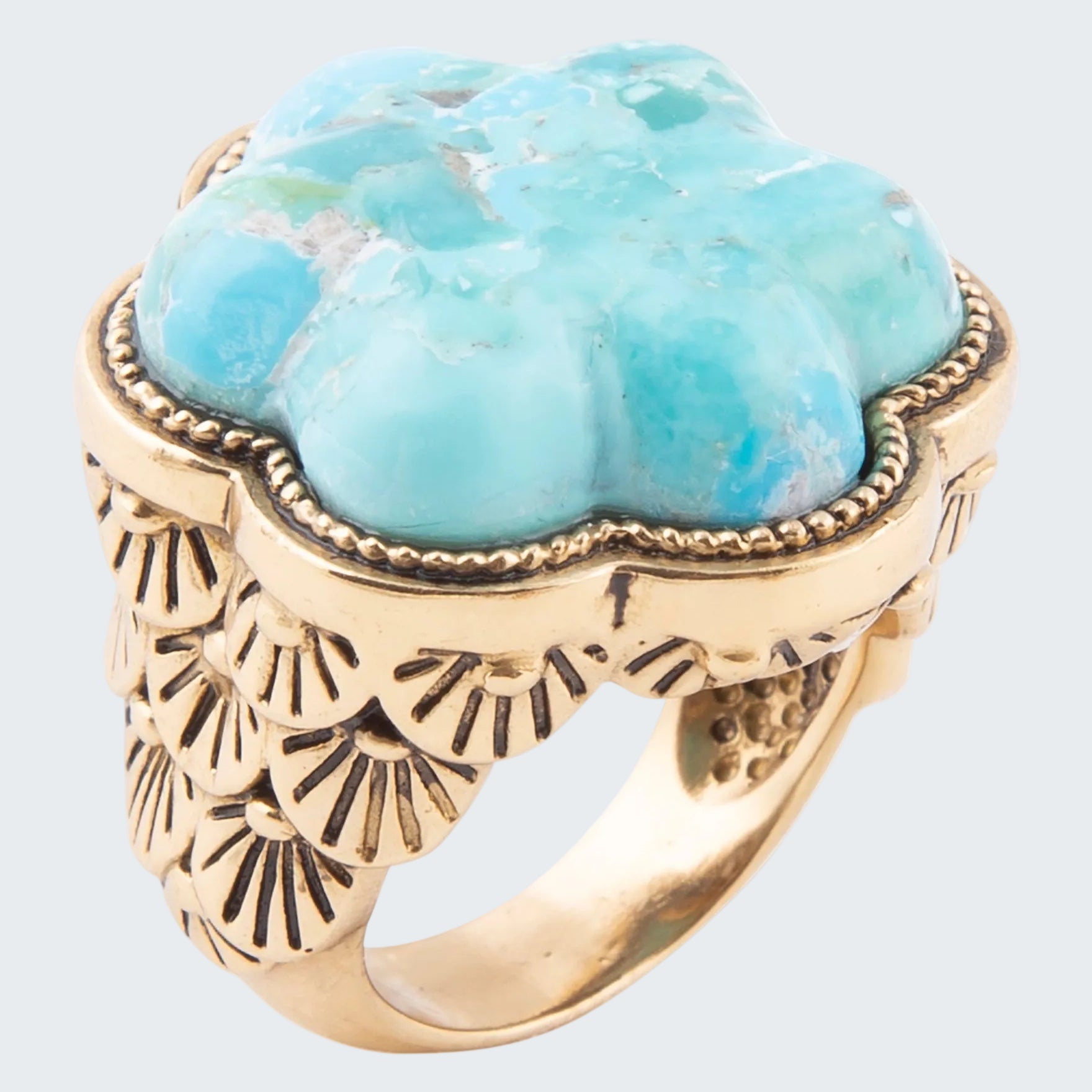 Ring with turquoise stone and gold band on a white background