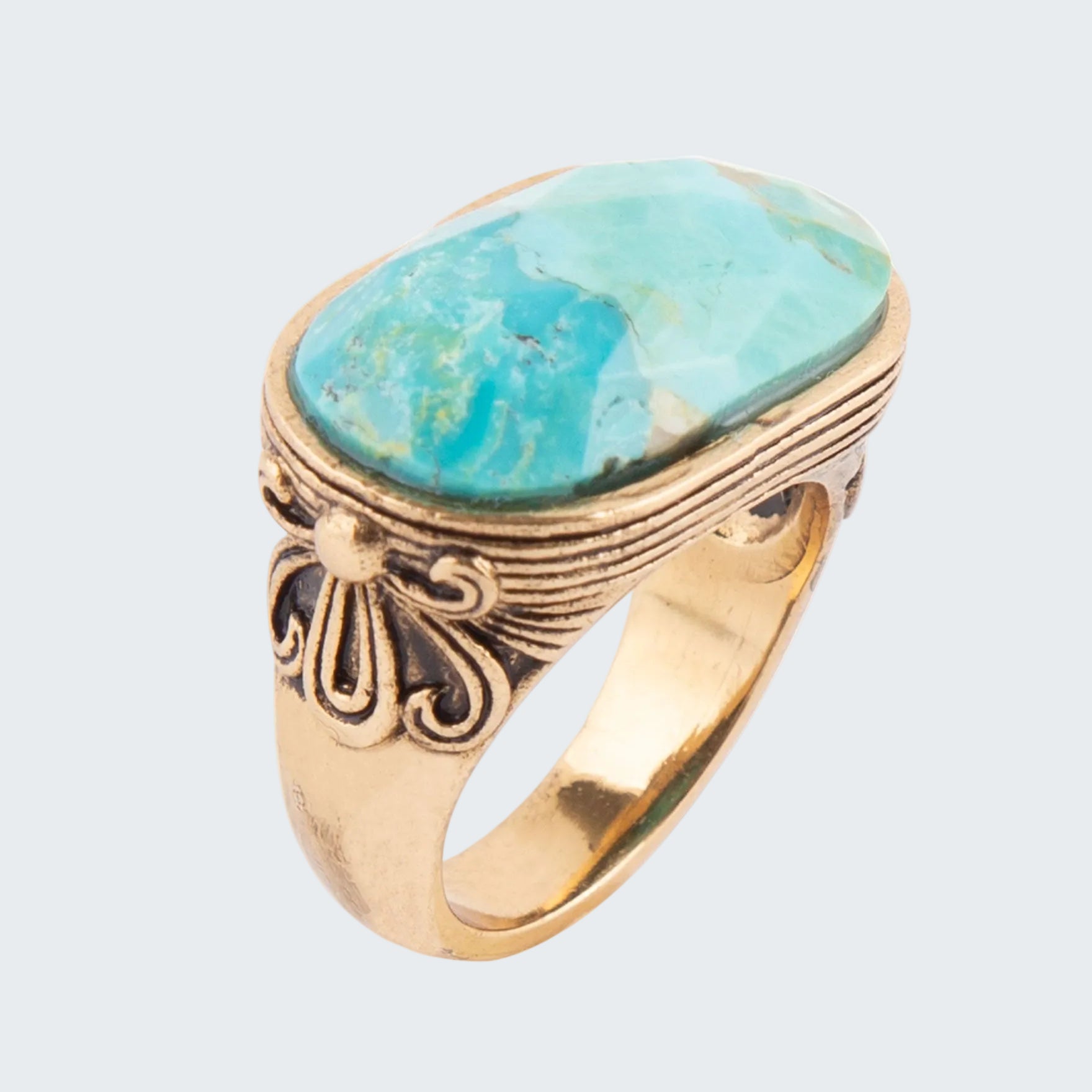 Gold ring with a large turquoise stone on a white background