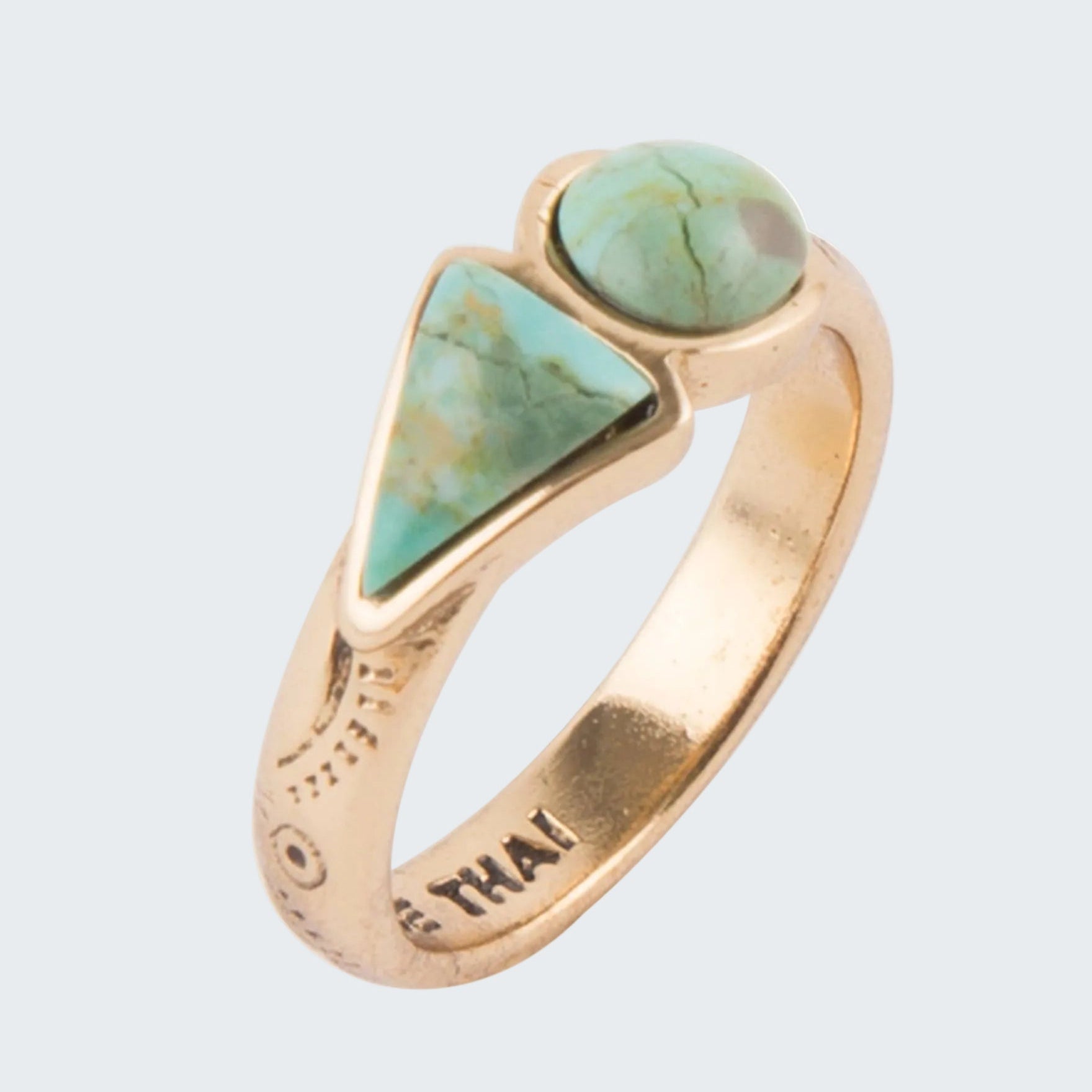 Gold ring with turquoise stones on a white background