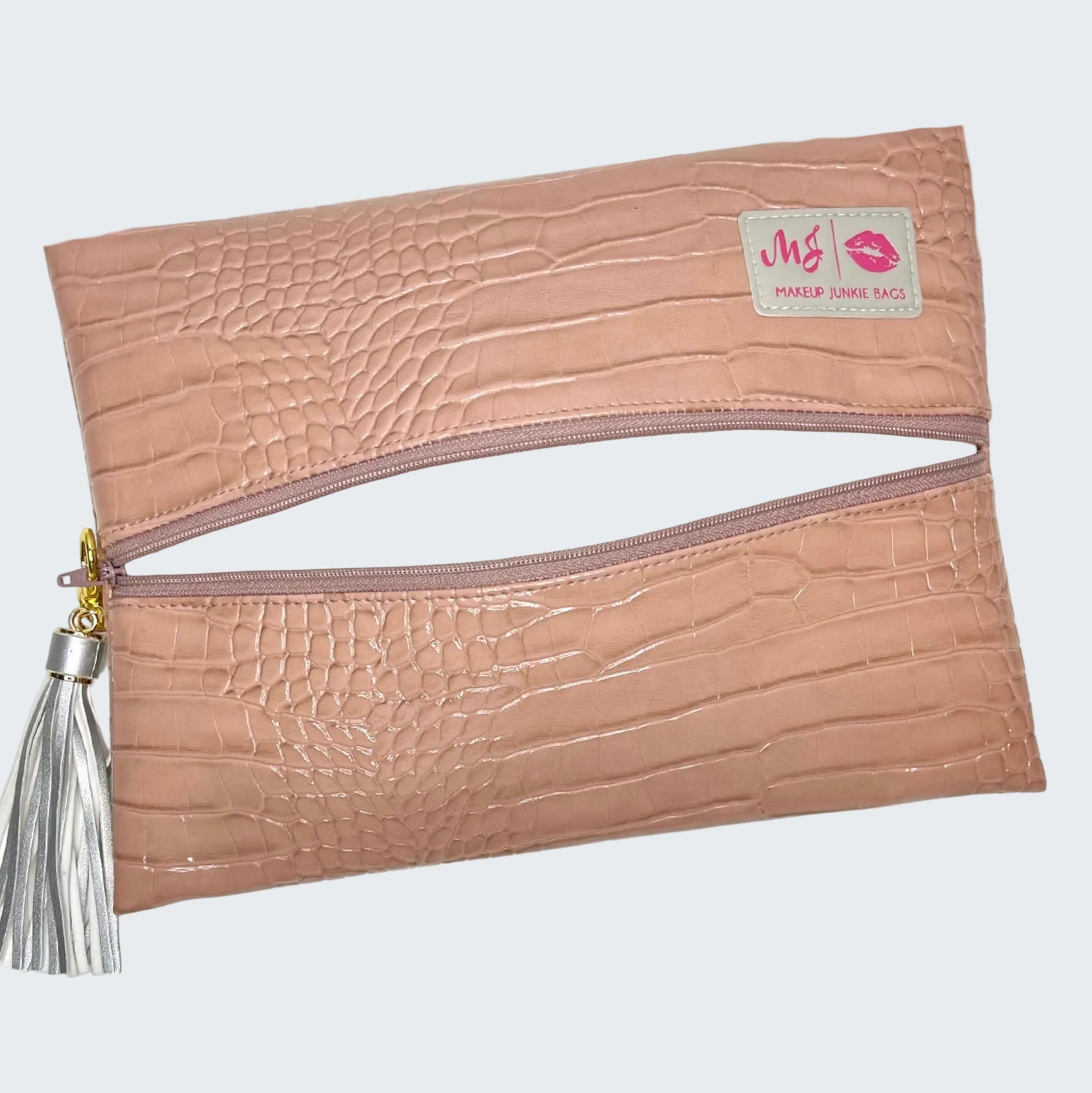 Pink textured clutch bag with a tassel on a white background
