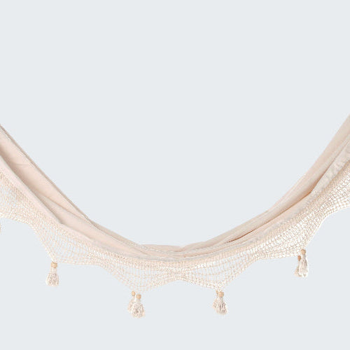 Beige hammock with tassels on a white background