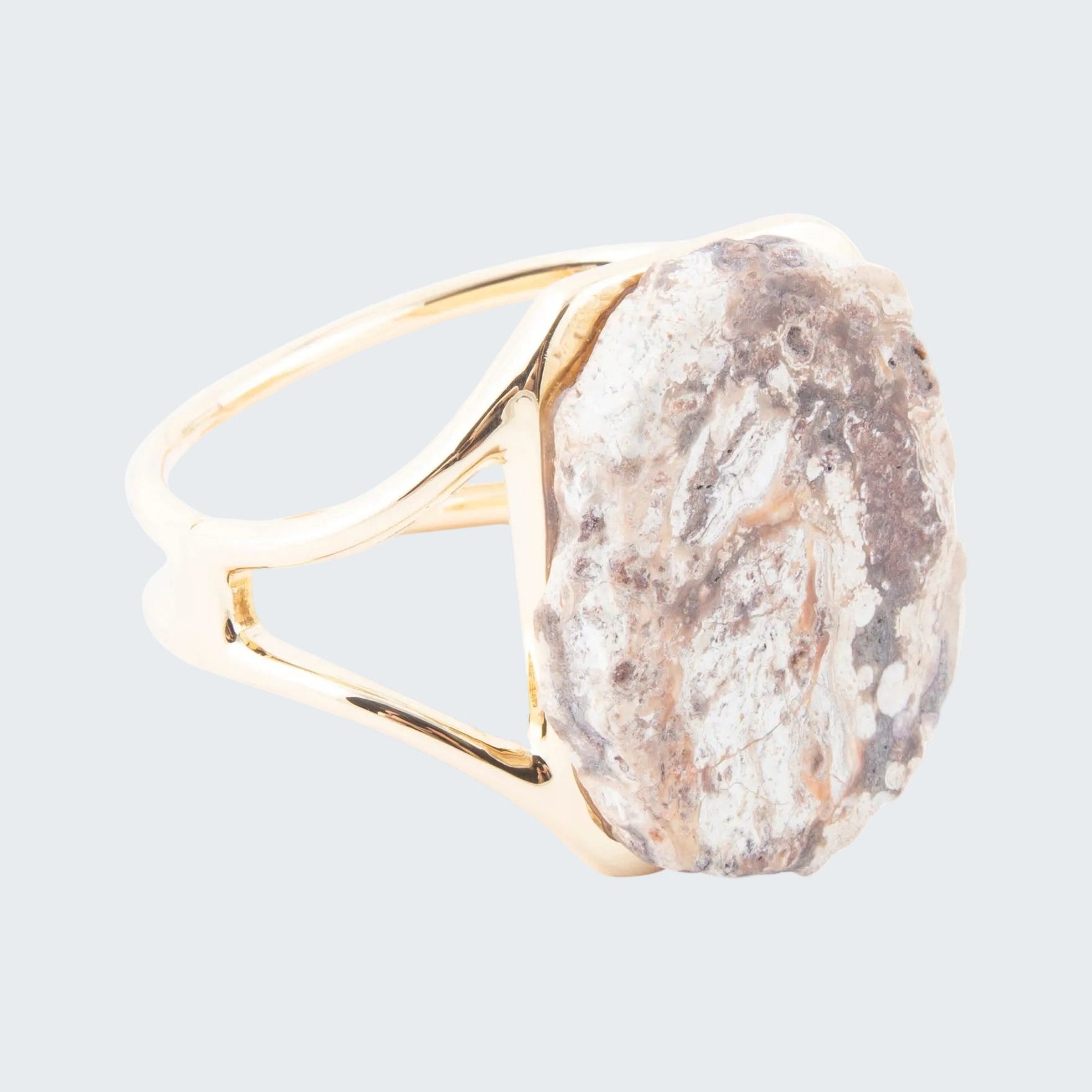 Ring with a gold band and large stone on a white background