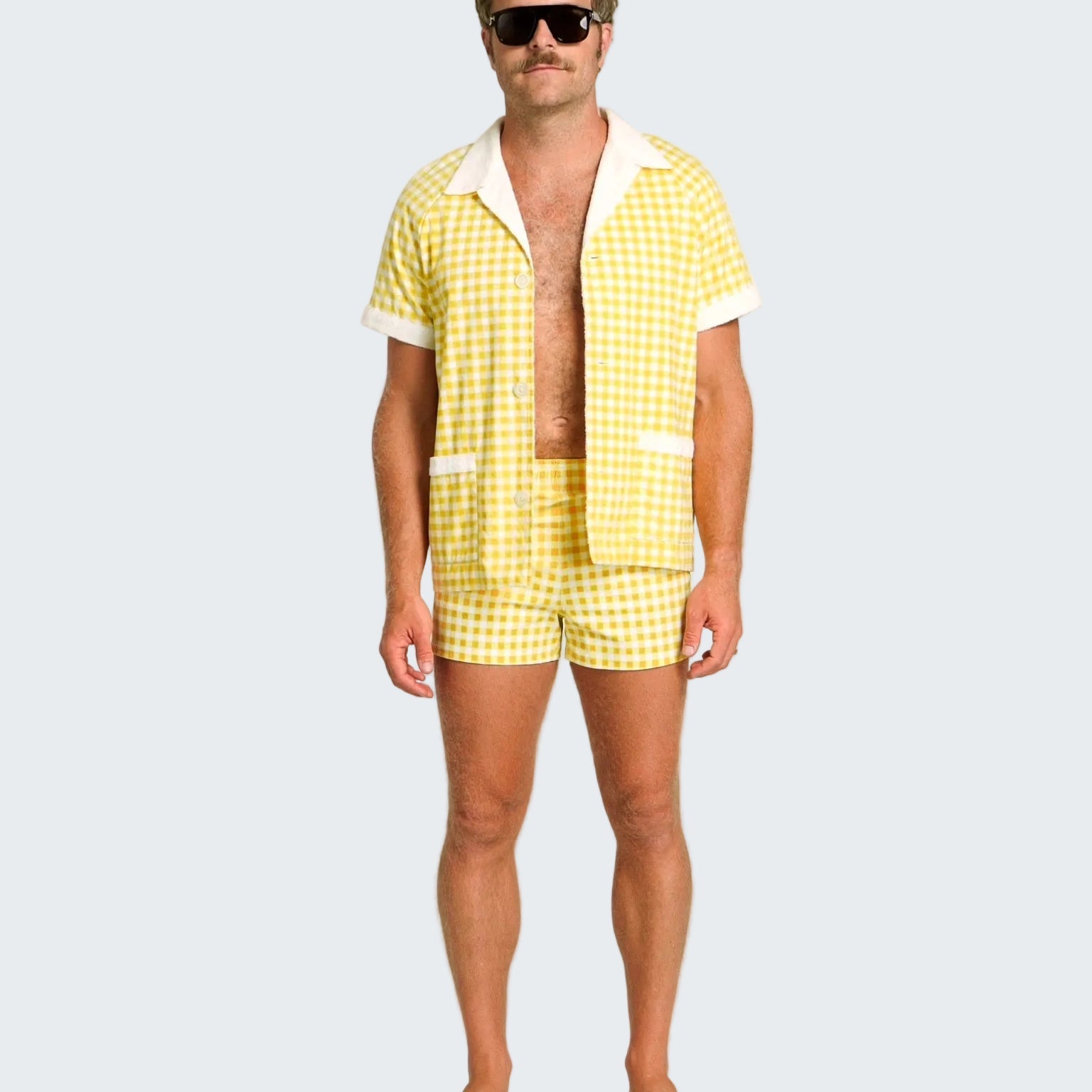 Man wearing a yellow checkered shirt and shorts set on a white background