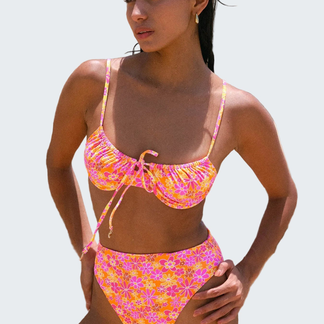 Woman wearing a colorful bikini set against a rocky background