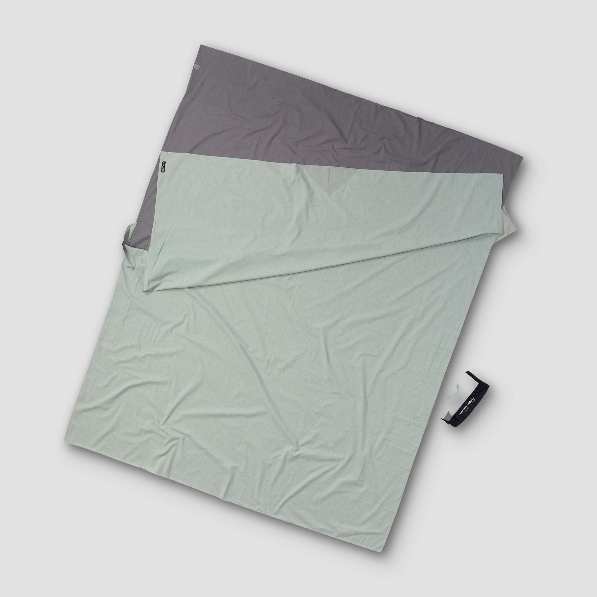 Folded green and gray fabric on a light gray background
