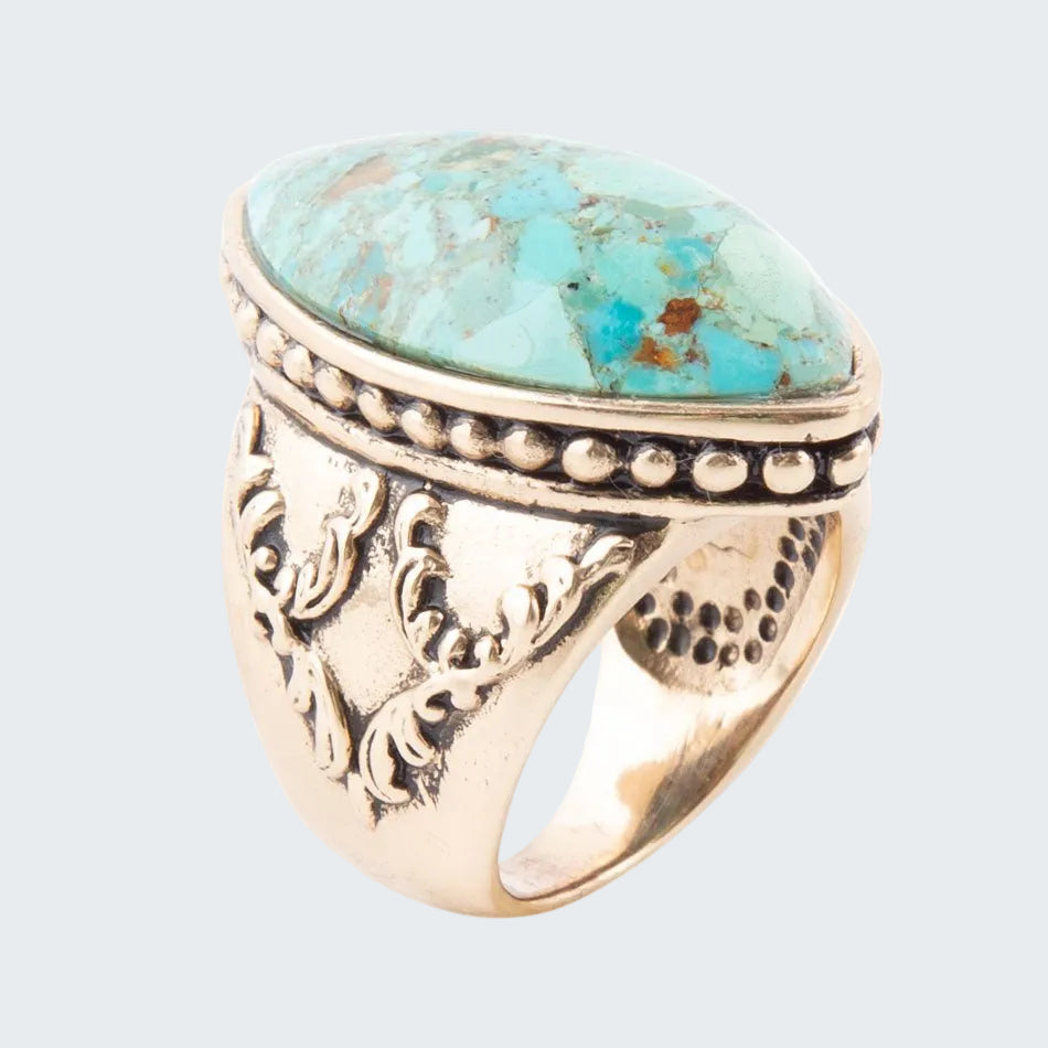 Gold ring with turquoise stone on a white background