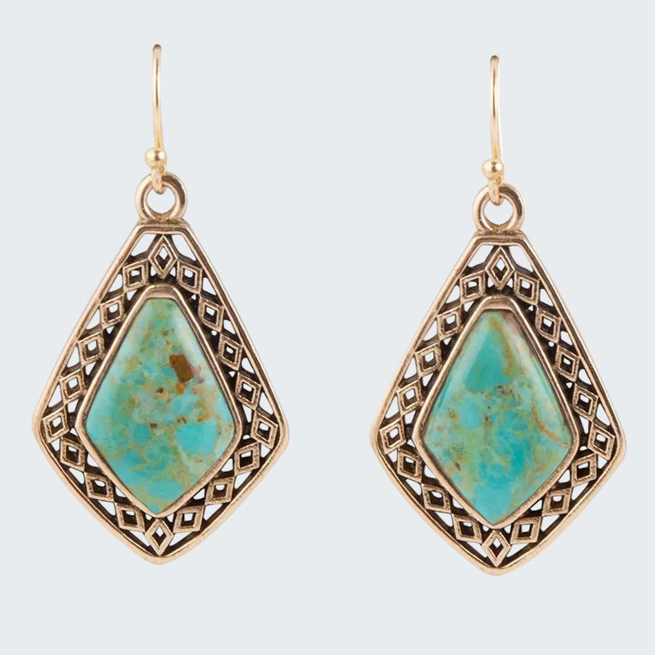 Pair of earrings with turquoise stones and gold frames on a white background